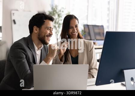 Équipe de deux professionnels collaborant dans le bureau moderne à l'aide de l'ordinateur Banque D'Images
