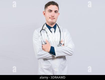 Portrait d'un beau médecin aux bras croisés isolé. Docteur latin avec les bras croisés sur fond blanc. Banque D'Images