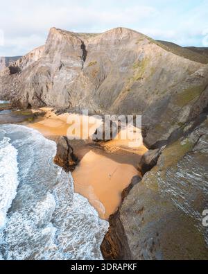 Vue aérienne des falaises escarpées embrassant une plage de sable isolée où l'océan turquoise s'écrase contre le rivage, Vila do Bispo, Faro District, Portu Banque D'Images