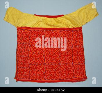 Cette blouse mola du début du XXe siècle est en coton avec un empiècement jaune et un coton rouge cousu autour du cou. Le dos du corps est en coton Bordeaux imprimé avec des fleurs blanches. Le motif appliqué en orange et rouge montre des motifs abstraits, avec du coton rouge autour de l'ourlet inférieur. La blouse illustre l'art textile traditionnel, les techniques d'applique, les vêtements indigènes, les motifs décoratifs géométriques et abstraits, et la production de vêtements artisanaux. Banque D'Images