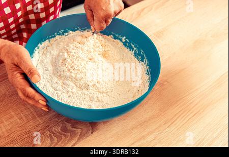 Femme pétrissant la pâte à la main pâte à levure. Femme chef préparant la pâte sur la table de cuisine Banque D'Images