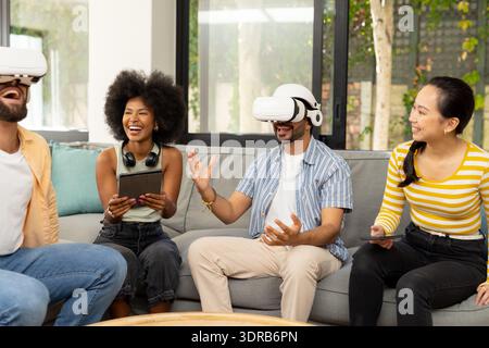 En utilisant des casques VR, divers amis appréciant l'expérience de réalité virtuelle ensemble à l'intérieur Banque D'Images