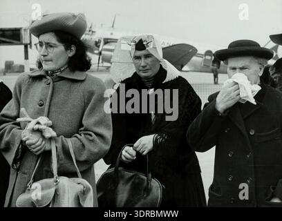 En 1948, à l'aéroport de Schiphol, une famille fait ses adieux au père Cornelius van 't Westeinde des Oblats de François de Sales alors qu'il retourne dans sa zone de mission dans le désert du Kalahari, en Afrique du Sud. Les membres de la famille manifestent de l'émotion, avec un frère tenant un mouchoir. La scène montre les procédures de départ, les voyages du milieu du XXe siècle, l'environnement aéroportuaire, les vêtements et les bagages. Cela illustre le travail missionnaire catholique, les liens familiaux, l’engagement religieux et les voyages internationaux d’après-guerre depuis les pays-Bas. Banque D'Images