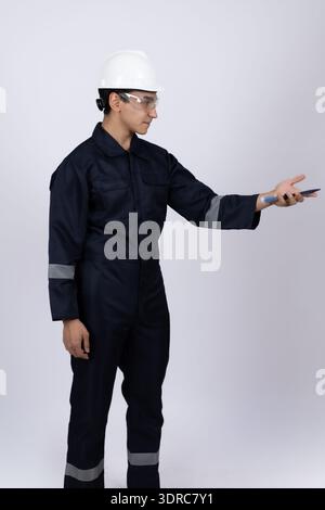 Ouvrier industriel en uniforme bleu présentant un espace de copie vide Banque D'Images