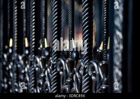 Clôture décorative en fer forgé noir avec forgeage artistique. Garde-corps en métal en gros plan. Banque D'Images
