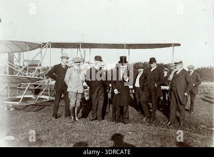 Photographie de l'histoire de l'aviation prise à la Haye aux pays-Bas en 1909 montrant le pilote Lefebvre un élève de Wilbur Wright lors d'un vol de démonstration d'une durée de 24 minutes. L'avion est un biplan Wright modèle A propulsé par un moteur à piston quatre cylindres en ligne refroidi par eau entraînant des hélices à deux poussoirs par transmission par chaîne. L'image illustre les premiers observateurs au sol motorisés et le champ de vol ouvert utilisé pour les démonstrations d'aviation publique aux pays-Bas. Banque D'Images