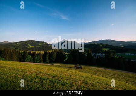 Paysage de montagne pittoresque avec un petit village niché dans la vallée pendant l'heure dorée Banque D'Images