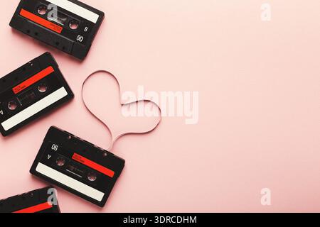 Ruban cassette collage avec forme de coeur sur un fond rose mettant en vedette des éléments de musique et de nostalgie Banque D'Images