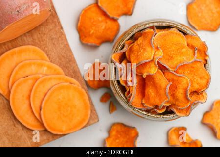 Croustilles douces biologiques saines dans un bol et patates douces fraîches Banque D'Images