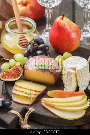 Ensemble de fromages fins aux fruits et au miel. Camembert. Bree. Raisins, figues, poires Banque D'Images