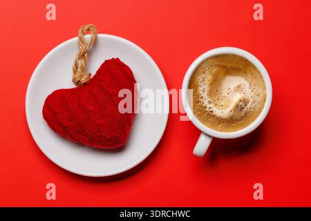Une délicieuse combinaison d'une tasse de café vapeur et d'un cadeau en forme de cœur Banque D'Images