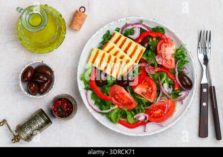 Délicieuse salade avec fromage halloumi grillé, laitue, tomates, poivrons, oignons rouges, olives Kalamata, huile d'olive, épices. M Banque D'Images