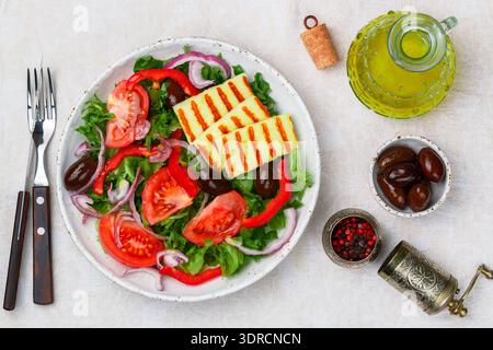 Délicieuse salade avec fromage halloumi grillé, laitue, tomates, poivrons, oignons rouges, olives Kalamata, huile d'olive, épices. M Banque D'Images