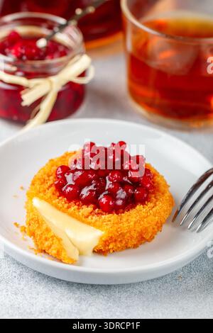 Cuit au four ou frit (camembert grillé ou brie avec sauce aux canneberges (airelle, cowberry) ou confiture. Petit déjeuner traditionnel gastronomique Banque D'Images