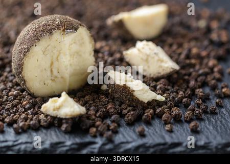 Belper knolle - fromage suisse à pâte dure sous forme de petites boules saupoudrées de poivre noir couper en deux Banque D'Images