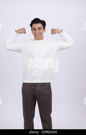 Jeune homme en vêtements décontractés debout et souriant Banque D'Images