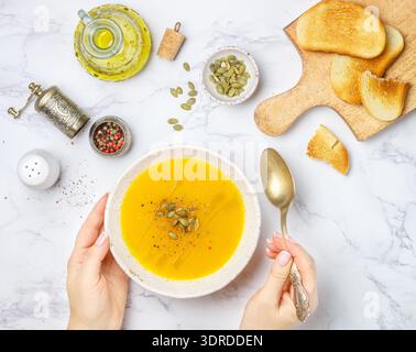 Purée de soupe à la crème végétarienne diététique de citrouille, de carotte et de pomme de terre avec de l'huile d'olive, des graines et des épices Banque D'Images
