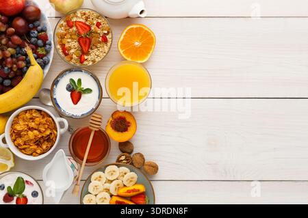 Petit déjeuner Collection de fruits, yaourt, granola et boissons sur une table en bois Banque D'Images