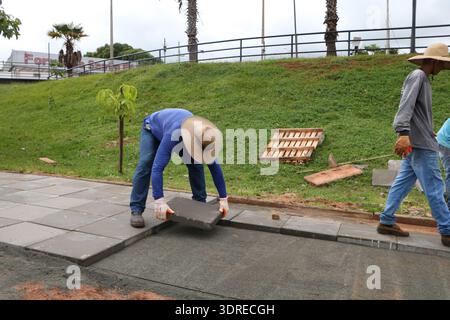 La photographie montre le personnel municipal effectuant le remplacement du plancher au Parque da Cultura à Votuporanga le 30 janvier 2023 à 9 h 41. Les travailleurs retirent les vieux revêtements de sol et posent de nouveaux carreaux pour entretenir les installations du parc. L'image met l'accent sur les protocoles de sécurité, les outils de construction, la supervision de projet, la gestion de l'infrastructure et les améliorations de l'accessibilité. L’initiative améliore les aires récréatives urbaines, démontrant l’engagement municipal envers les espaces communautaires et l’entretien structuré de l’infrastructure des parcs publics. Banque D'Images