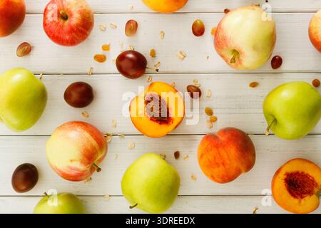 Collection de fruits sur une surface en bois dans un arrangement coloré avec quelques morceaux coupés Banque D'Images