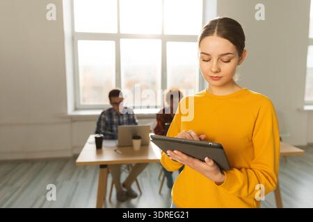 Portrait d'une femme d'affaires chef d'équipe féminine debout dans le bureau avec des collègues se réunissant en arrière-plan. Souriant Busines confiant Banque D'Images