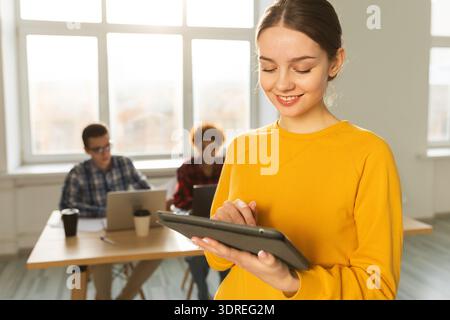 Portrait d'une femme d'affaires chef d'équipe féminine debout dans le bureau avec des collègues se réunissant en arrière-plan. Souriant Busines confiant Banque D'Images