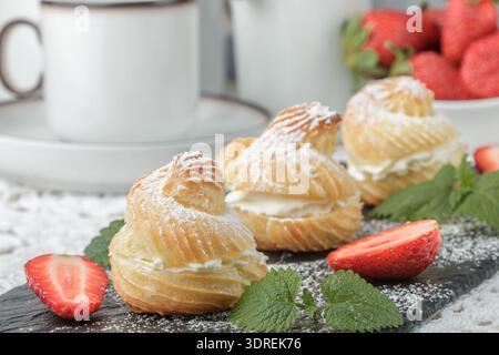 Profiteroles crème, fraises et menthe. Dessert pour les gourmets. Selective focus Banque D'Images