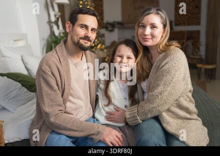 Famille heureuse à la maison. Mère père enfants fille détente sur le canapé intérieur. Maman papa parents enfant fille se détendre jouant câlin ha Banque D'Images