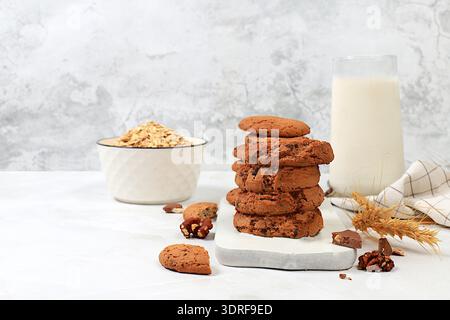 Biscuits à l'avoine faits maison fraîchement cuits avec des pépites de chocolat et des noix sans gluten avec des oreilles sur fond de béton, boulangerie moderne Banque D'Images