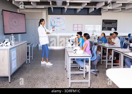 À l'école, enseignante indienne expliquant l'expérience scientifique aux élèves dans le laboratoire de classe Banque D'Images