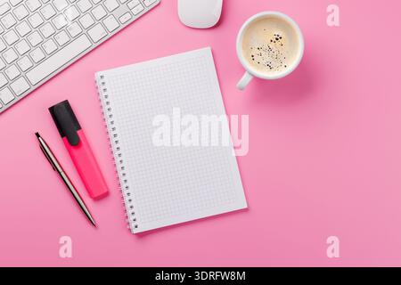 Vue de dessus d'un bureau rose avec fournitures de bureau, tasse à café et bloc-notes vierge. Espace de travail féminin et créatif avec espace de copie Banque D'Images