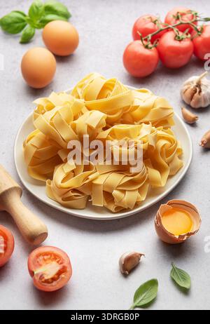 Pâtes pappardelle non cuites avec des ingrédients formant cadre sur la table Banque D'Images