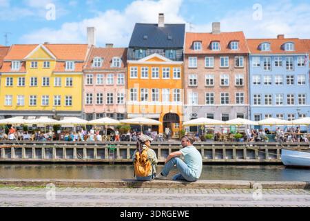 Bâtiments colorés au bord de l'eau et visiteurs détendus dans la charmante Copenhague Danemark Banque D'Images