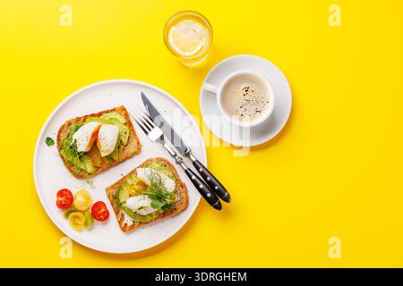 Délicieux toasts à l'avocat garni d'œufs pochés parfaitement cuits Banque D'Images