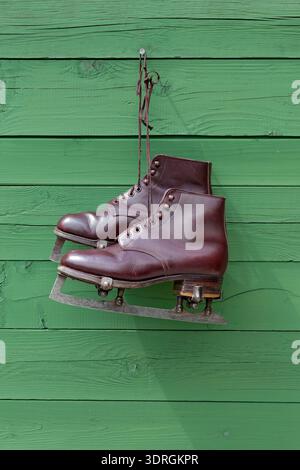 Paire vintage de patins à glace pour hommes accrochés sur un mur en bois Banque D'Images