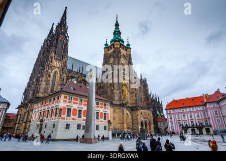 Prague, République tchèque - 24 novembre 2010 : les touristes explorent la troisième cour avec la cathédrale gothique St Vitus et l'obélisque de granit dans le mun Banque D'Images