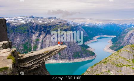 Vue imprenable depuis le bord d'une falaise en Norvège avec des randonneurs surplombant le fjord Banque D'Images