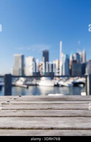 Une table de barbecue en bois vide placée à l'extérieur avec une vue floue sur l'emblématique horizon de Manhattan Banque D'Images