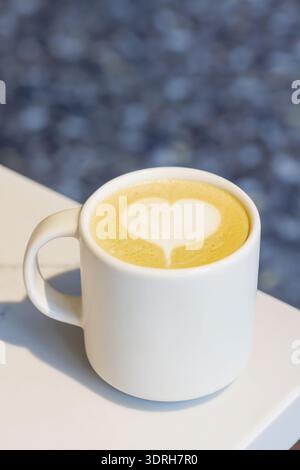 Cappuccino chaud dans une tasse avec un motif latte en forme de cœur sur le dessus Banque D'Images
