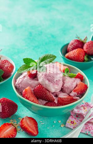 Crème glacée aux fraises maison avec des baies fraîches et de la menthe dans un bol à grenn Banque D'Images