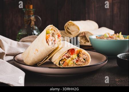 Shawarma maison avec poulet, tomate et concombre dans du pain pita sur une assiette Banque D'Images