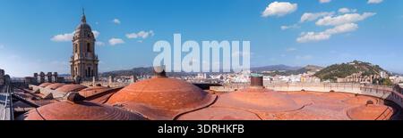 Large panorama sur le toit de la cathédrale de Malaga avec dômes en terre cuite et clocher. Espagne. Soleil brillant sur la ville méditerranéenne. Paysage architectural et hi Banque D'Images