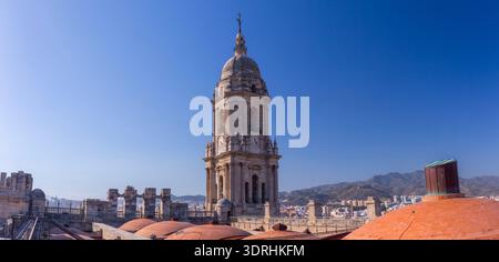 Large panorama sur le toit de la cathédrale de Malaga avec dômes en terre cuite et clocher. Espagne. Soleil brillant sur la ville méditerranéenne. Paysage architectural et hi Banque D'Images