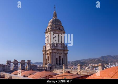 Large panorama sur le toit de la cathédrale de Malaga avec dômes en terre cuite et clocher. Espagne. Soleil brillant sur la ville méditerranéenne. Paysage architectural et hi Banque D'Images
