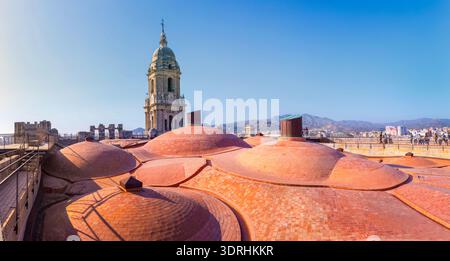 Large panorama sur le toit de la cathédrale de Malaga avec dômes en terre cuite et clocher. Espagne. Soleil brillant sur la ville méditerranéenne. Paysage architectural et hi Banque D'Images