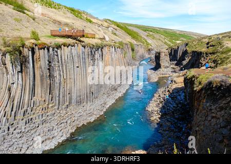 Explorez le paysage époustouflant du canyon Studlagil en Islande, avec des colonnes de basalte saisissantes et une rivière bleue éclatante Banque D'Images