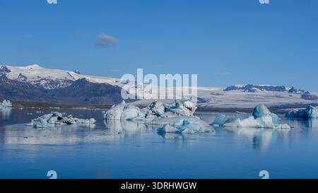 Vue imprenable sur la lagune du glacier Jokulsarlon entourée de superbes icebergs et montagnes Banque D'Images