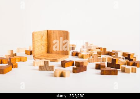 Puzzles en bois et boîte de collecte vide sur fond clair Banque D'Images