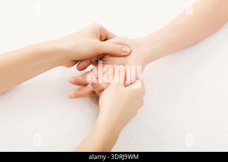 Mains appliquant une pression sur une autre main pendant une séance de massage axée sur les techniques de relaxation Banque D'Images
