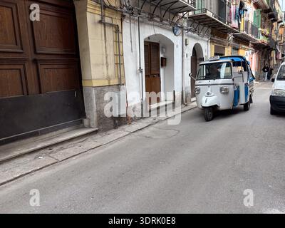 Piaggio APE Taxi (APE car). Véhicule pousse-pousse automatique à trois roues conduisant dans une rue étroite et historique à Palerme, Sicile, Italie. Banque D'Images